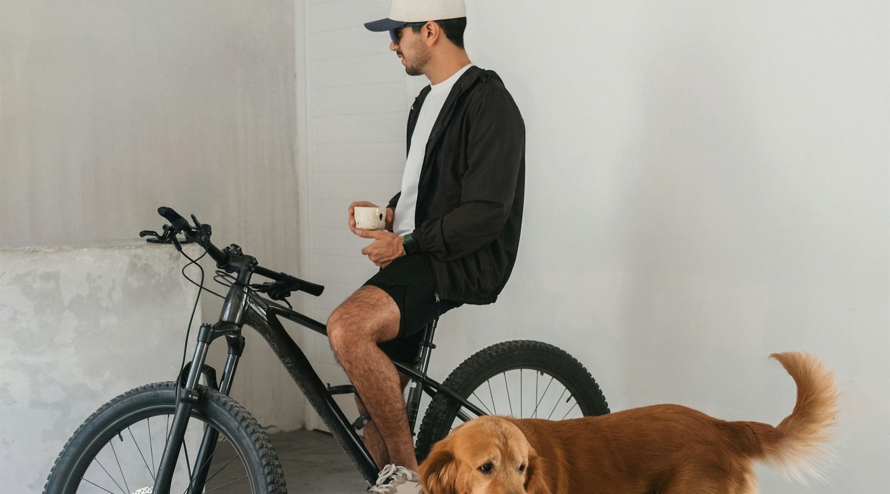 a man sitting on a bike with a dog